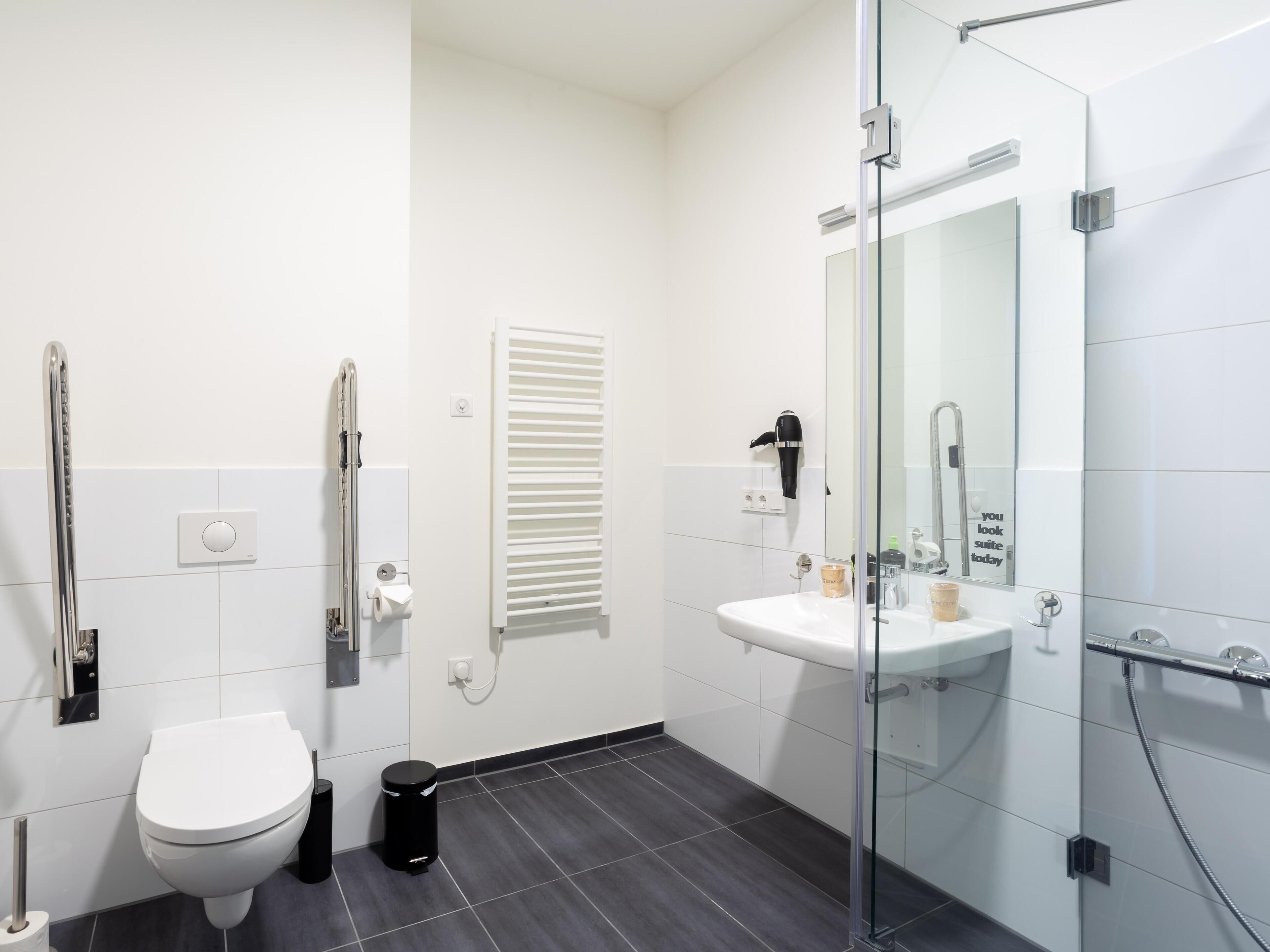 A modern bathroom with a toilet, bidet, and a glass-enclosed shower area.