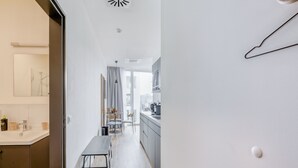 A modern kitchen with a dining area, a bench, and a view of the city. - Limehome Mönchengladbach Fliethstraße (Moenchengladbach)