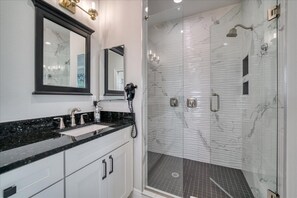 Een bad/douchecombinatie, een haardroger, handdoeken, toiletpapier
