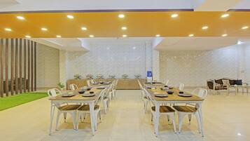 A spacious conference room with a long table and chairs, a buffet area, and a seating area with a sofa and chairs.