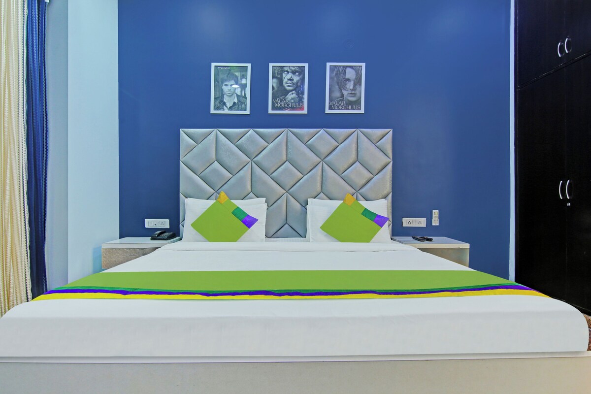 A bedroom with a bed, a headboard, two bedside tables, and a wardrobe.