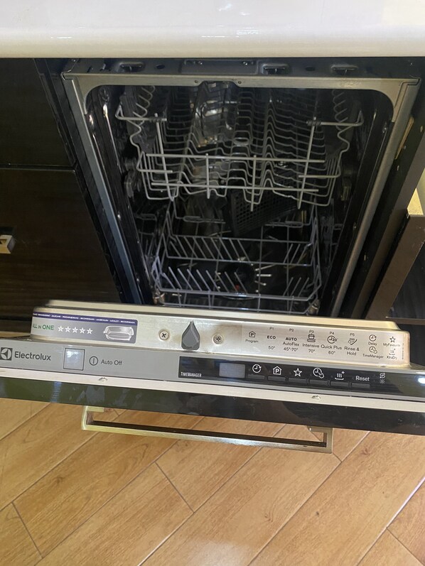 An open dishwasher with a control panel displaying various settings and options.