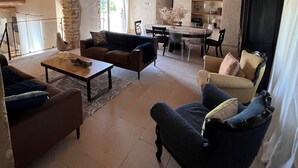 A spacious living area with a high wooden ceiling, stone archway, and a dining area with a table and chairs. - Authentic House, near Uzès, amazing view (Le Pin)