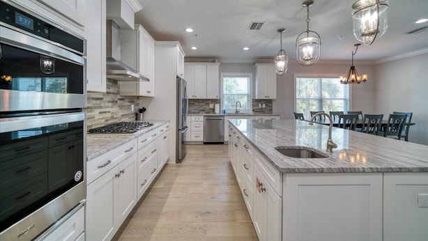 A modern kitchen with white cabinets, stainless steel appliances, and a marble countertop. - ♥ BEACH CONDO ♥ NEW ♥ SLEEPS 10 ♥ 3 BD 2.5 BA ♥ U4 (Indian Rocks Beach)