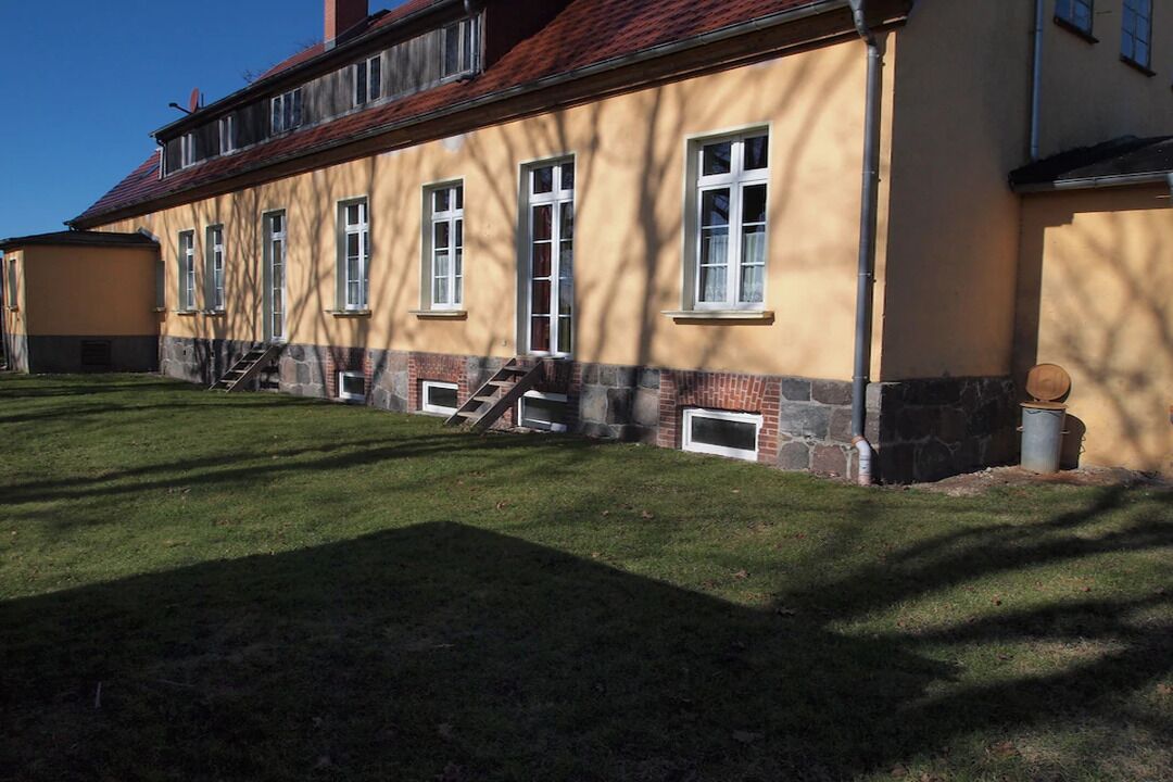 Kaksikerroksinen rakennus, jonka julkisivu on keltainen ja pohjaosa kivestä. Rakennukseen johtaa portaat.
