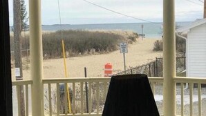 Et værelse med udsigt over en strand og et skilt, der viser vejen til stranden.