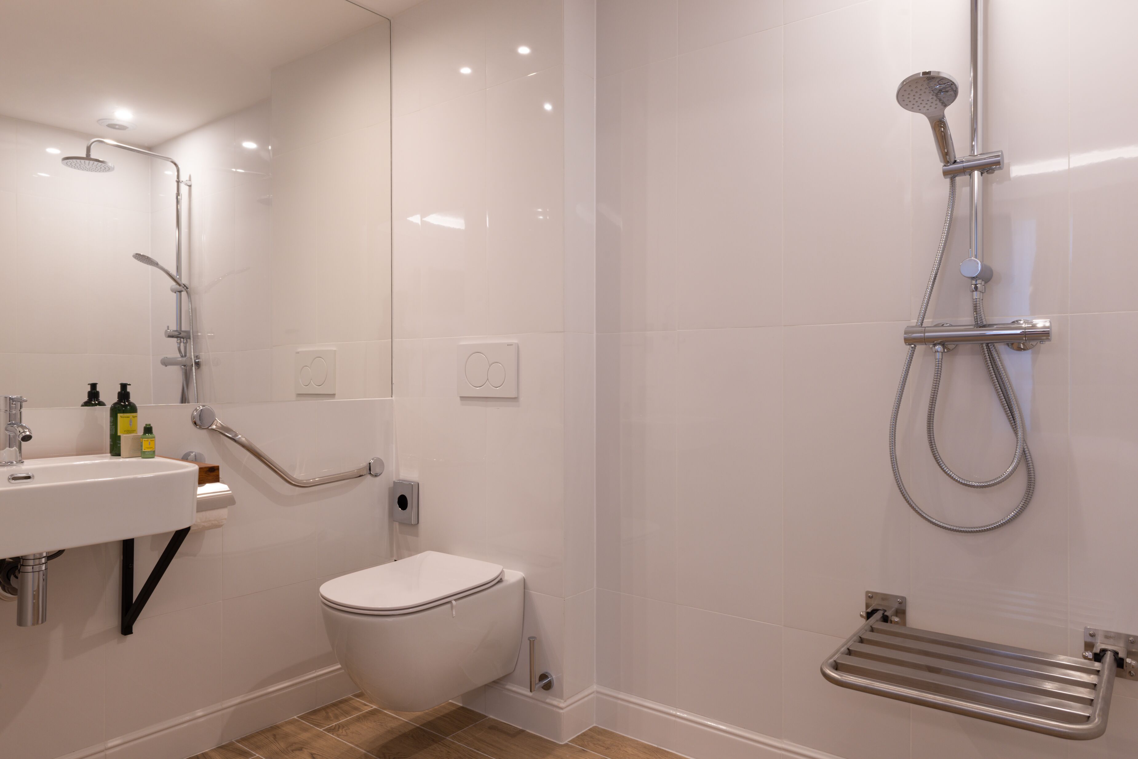 Un baño moderno con inodoro, lavamanos y ducha.