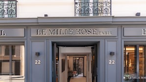 The entrance to Le Milie Rose Paris, featuring a modern design with a glass door and a metal balcony. - Hôtel Le Milie Rose (Paris)