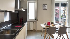 Eine moderne Küche mit einer Spüle aus Edelstahl, einem roten Transportkocher und einem Essbereich mit Tisch für zwei Personen.