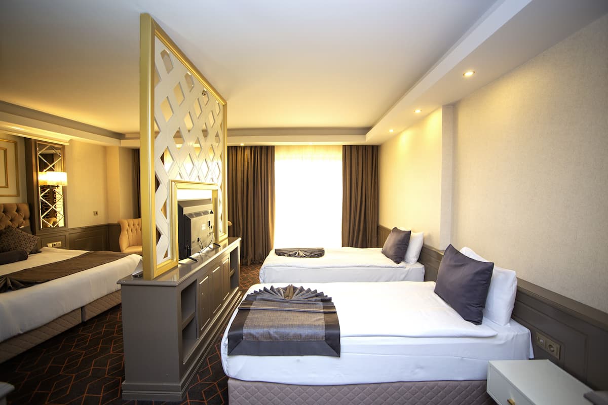 Ein Hotelzimmer mit zwei Betten, einem Schreibtisch und einem großen Fenster.