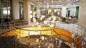 A spacious lobby with a marble floor, a central seating area with sofas, and a staircase with a metal railing. - Terma City Hotel (Termal)