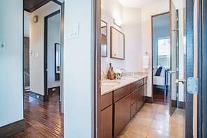 A modern bathroom with a large mirror, a sink, and a cabinet. - Charming Modern Home - Close to everything DT, UT! (Austin)