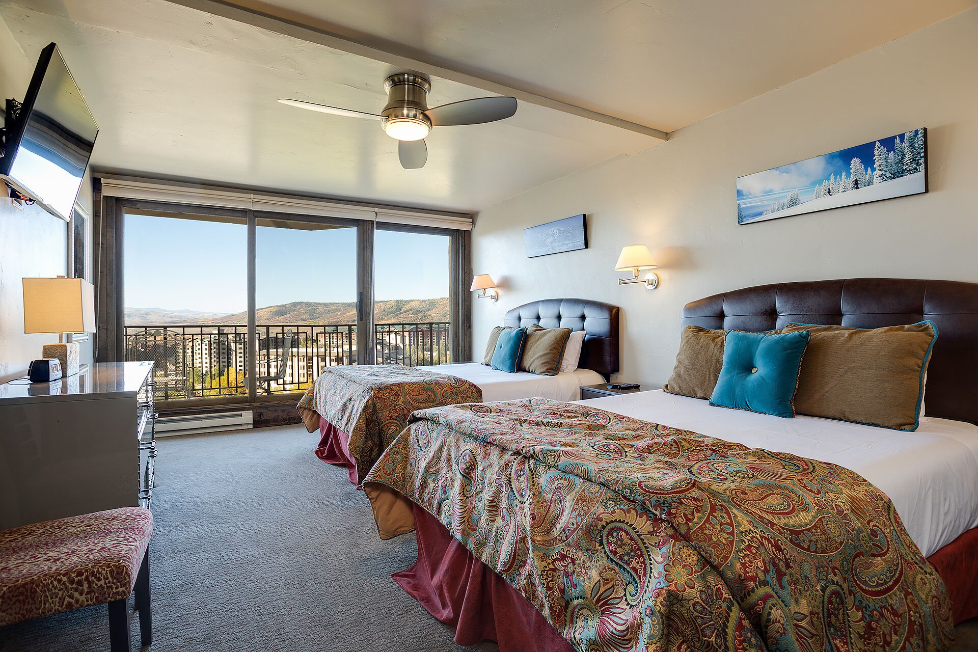 Une chambre d’hôtel avec un grand lit, un bureau et un balcon avec vue.