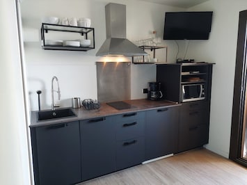Cuisine toute équipée : plaques à induction, lave-vaisselle, lave linge, TV....
