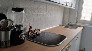 A kitchen with a countertop, a blender, a sink, and a backsplash. - Balcón a la Bahía. Bay Views (Santander)