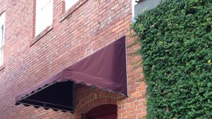 A red door with a sign reading "ArtLofts" and a covered awning.