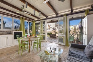 A spacious kitchen with a dining area, a glass coffee table, and a sofa.