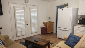 A living room with beige sofas, a wooden coffee table, and a clock on the wall. - Country setting only 10 minutes to  Downtown. (Naples)