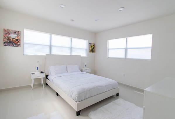 A modern bedroom with a white bed, nightstands, and a fluffy rug. - House Close to Hard Rock, Downtown & Beach Luxury (Hollywood)