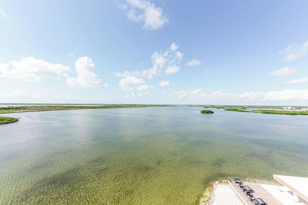 An aerial view of a large body of water with clear skies and a few clouds.