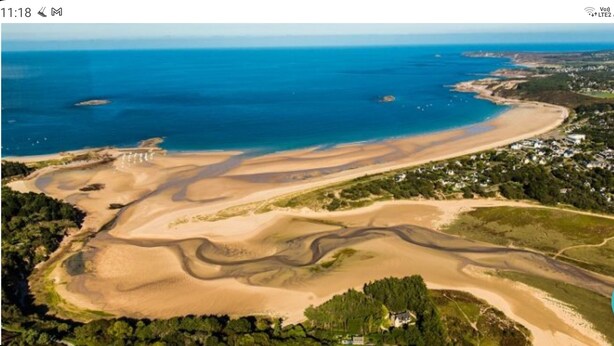 An aerial view of a coastal area with a beach, sand dunes, and residential buildings. - Apartment sables d'or les pins (Fréhel)