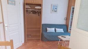 A room with a bed, a wardrobe, a table, and a chair. - Apartment sables d'or les pins (Fréhel)