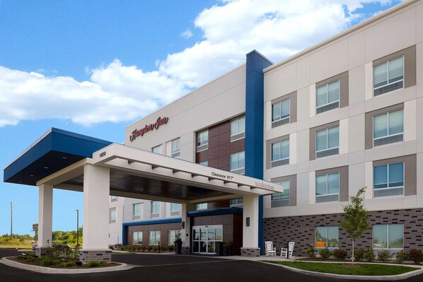 A hotel with a modern design, a covered entrance, and a clear sign indicating a 147-meter clearance. - Hampton Inn Crown Point (Crown Point)