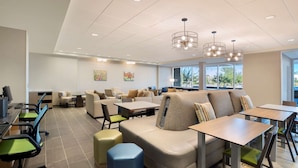 A modern dining area with multiple seating options including sofas, tables, and chairs. - Home2 Suites by Hilton Phoenix Avondale (Avondale)