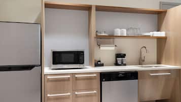 A modern kitchen with a built-in microwave, coffee maker, and dishwasher.