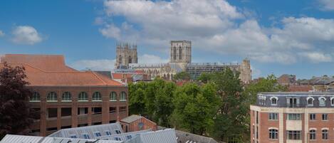 A cityscape with historic buildings and modern architecture, including a prominent cathedral and a large tower.
