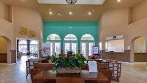 Eine geräumige Lobby mit einer zentralen Sitzecke, großen Fenstern und einer Rezeption.