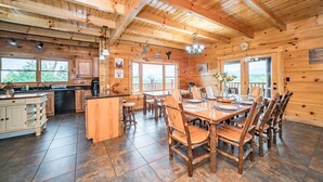 L’intérieur d’un chalet en bois comprend une cuisine, un coin repas et de grandes fenêtres.