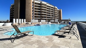 Ein Hotel mit großem Pool, mehreren Balkonen und freiem Blick auf den Ozean.