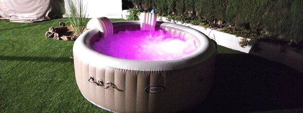 Relax in a hot tub surrounded by a beautifully manicured lawn.