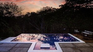 An outdoor swimming pool with a view of trees and a sunset. - Casa completa dentro de un complejo privado con seguridad 24/7 (La Libertad)