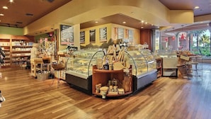 Une boulangerie avec un comptoir incurvé, des vitrines et une grande variété de produits de boulangerie.