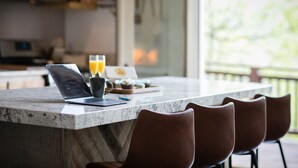 A kitchen with a laptop, two glasses of orange juice, and a plate of food on the counter. - Lake Life Mountain & Lake Views, Hot Tub, & Dock (Butler)