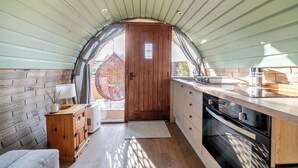 Een kleine keuken met houten kastjes, een spoelbak en een raam.