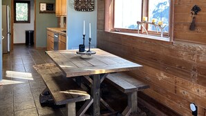 A rustic kitchen with wooden walls, a large wooden table, and a window with a view. - Spacious kid-friendly chalet minutes to Boone, Blowing Rock, Blue Ridge Pkwy (Boone)