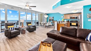 Una sala de estar amplia con un gran ventanal, un comedor y una cocina.