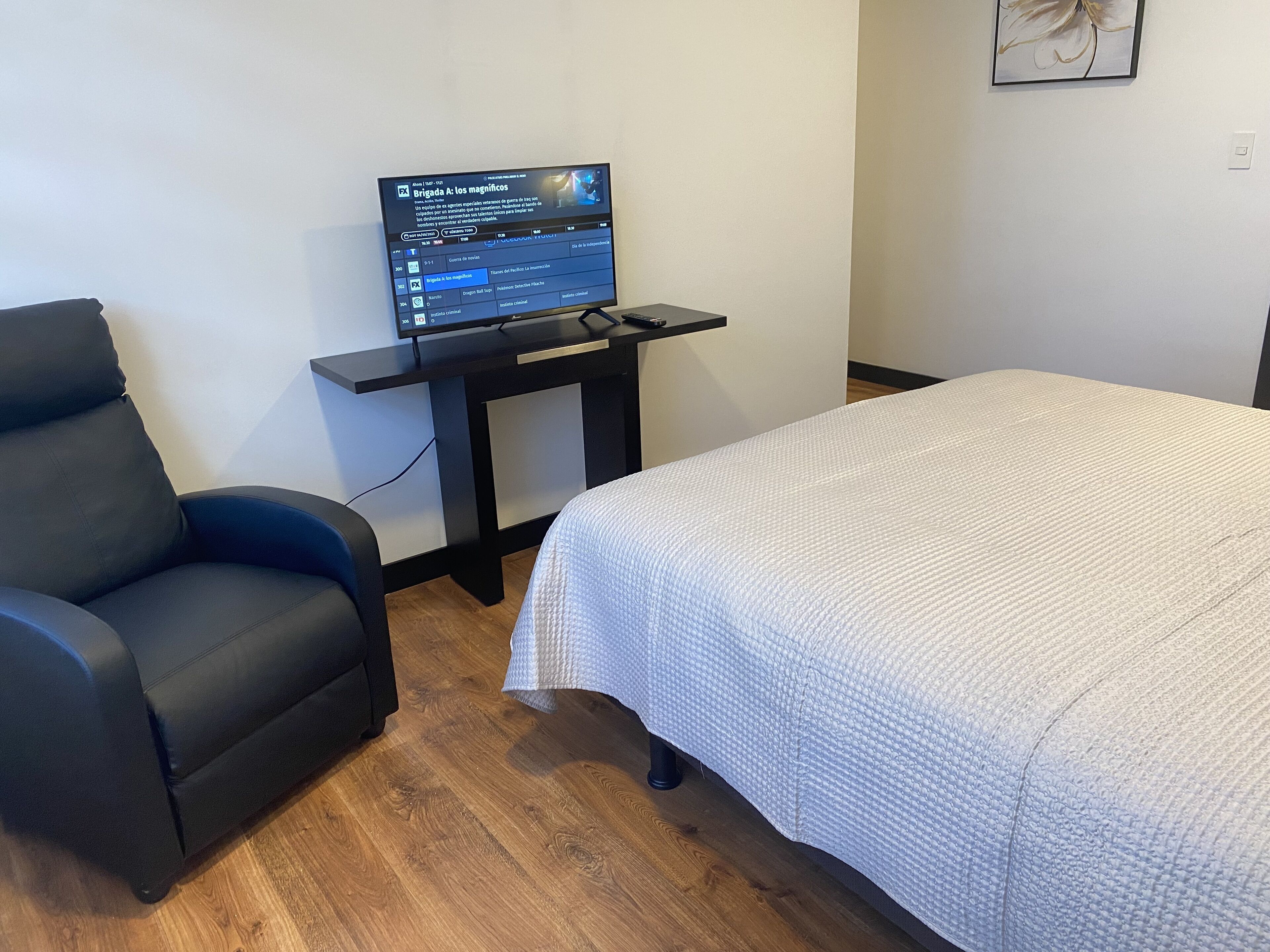 Una stanza con un letto, una scrivania con un computer e una sedia.