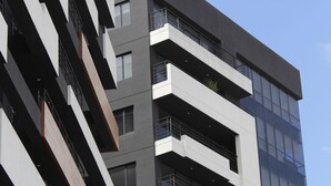 Un edificio moderno de varios pisos con balcones y ventanas amplias.