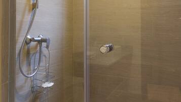 Un baño moderno con cabina de ducha de vidrio, inodoro y ventana.