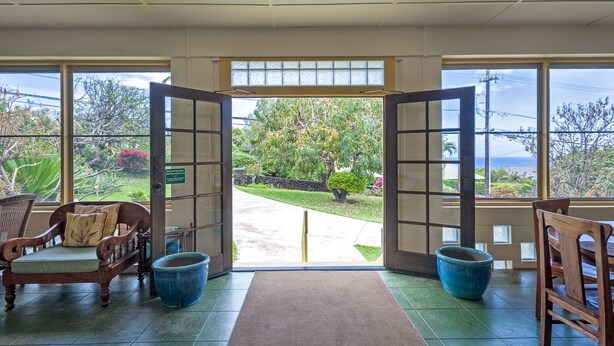 A room with a view of a garden and a pathway leading outside. There are two wooden chairs and a large blue pot on the floor. - 500 Feet to the Ocean!  (Koloa)