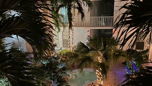 A pool area with palm trees and decorative lights. - Lovely renovated condo with water views, great value for outstanding amenities (Clearwater Beach)