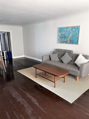Relax in this stylish living room with a tufted sofa, wooden coffee table, and abstract art.