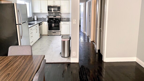 A modern kitchen with stainless steel appliances, white cabinetry, and a marble countertop. - Remodeled rental in the heart of West Hollywood WeHo  (West Hollywood)