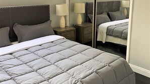 A bedroom with a bed, bedside tables, lamps, a wardrobe, and a mirror. - Remodeled rental in the heart of West Hollywood WeHo  (West Hollywood)