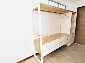 Un vestidor con un banco de madera, cajones y una barra para colgar ropa.