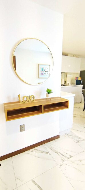 A wall-mounted mirror with a gold frame, a wooden shelf with a 'Love' sign, and a small potted plant. - Horacio 1 · Steps from Antara, Polanco · 2 baths (Ciudad de México)